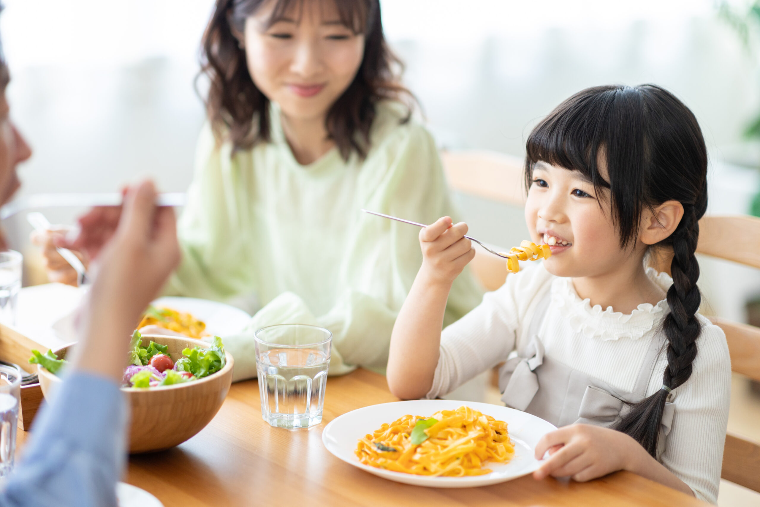 家族で食卓を囲むおさげの女の子